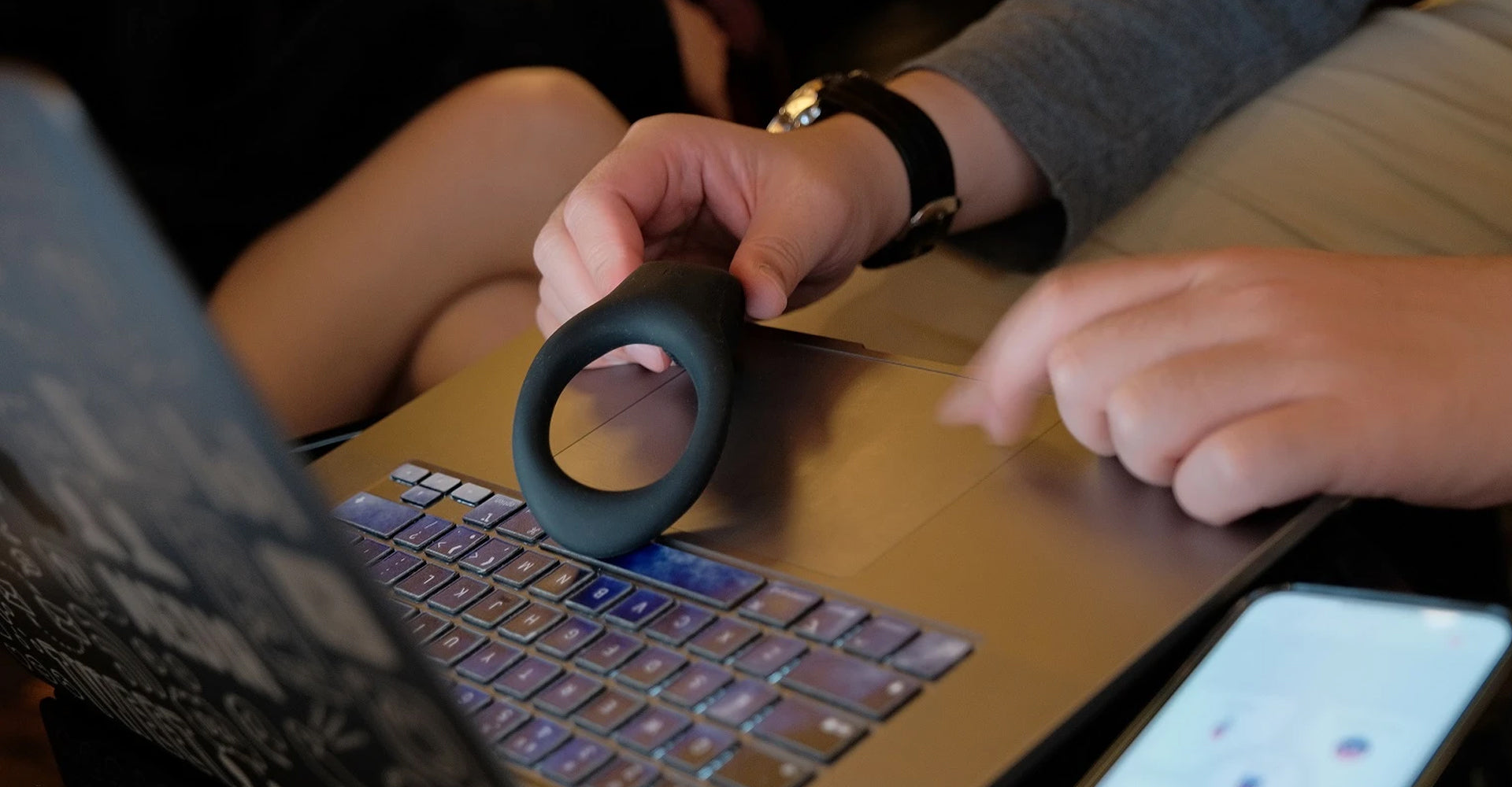 couples holding a lovense cock ring connection onto a laptop for app controlled